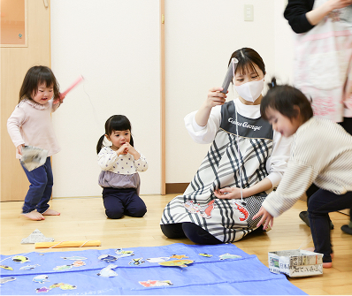 先生と一緒に遊ぶ園児たち